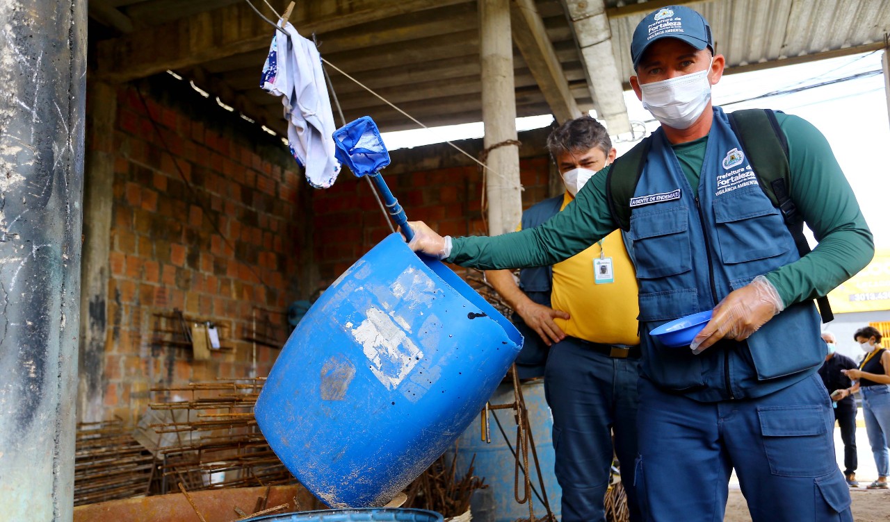 agente de endemia segura um balde para fazer a inspeção de focos de larvas do mosquito da dengue